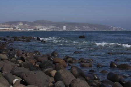 Huge rocks on the beach of Ensenada Baja California view of the city from the seaの写真素材