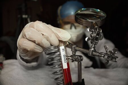 Scientist hand holding test tube with prototype plasma fluid for covid-19 vaccine in mexico city