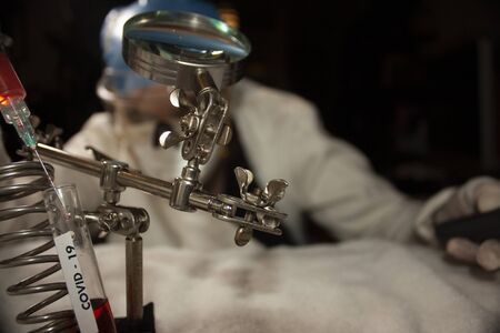 Study of biochemical reactions using tools such as test tubes and syringes to manipulate plasma by a research doctor in Mexico City in the new reality looking for a vaccine against covid-19の写真素材