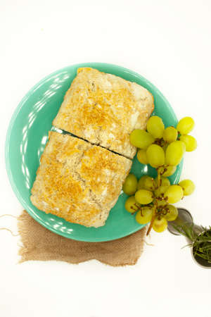 White bread located in top view isolated on white background next to fresh rosemary and grapes