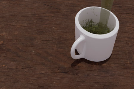 Green tea Matcha served by jet between steam and water splashes entering transparent white cup on rustic wooden table in Mexicoの写真素材