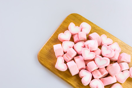Pink heart Marsh Mallow on wooden plateの写真素材