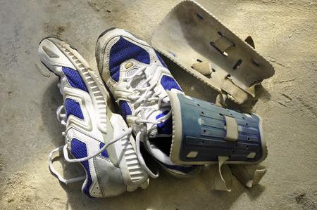 old used sport shoes and knee protectors on the concrete