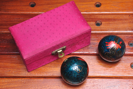 chinese hand massage balls with their pink box in wood backgroundの写真素材
