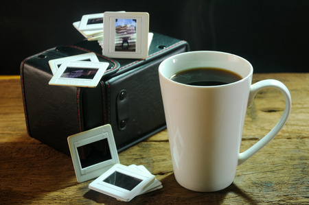 cup of coffee and old film slides of art and culture memories on wooden tableの写真素材