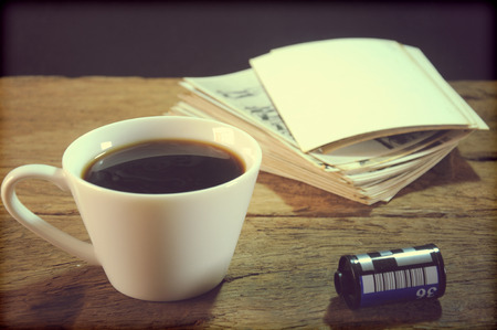 cup of coffee and old paper photo frame on wood backgroundの写真素材