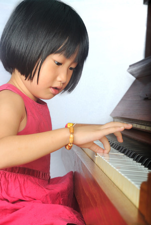 little asian child playing the pianoの写真素材