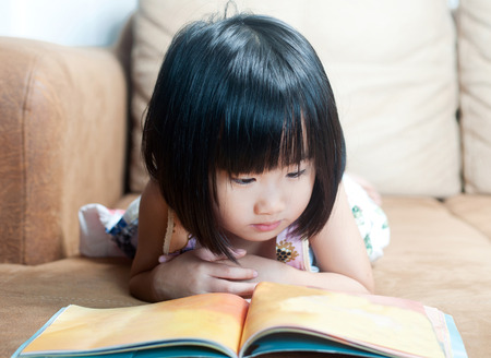 Asian little girl reading her bookの写真素材