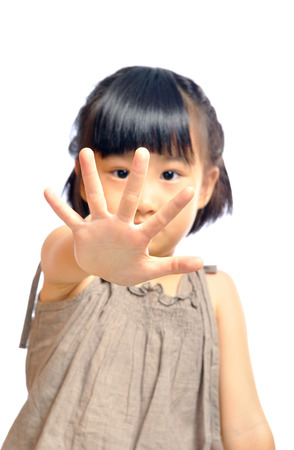 asian little girl holding a stop sign with her hand, selective focus on handの写真素材