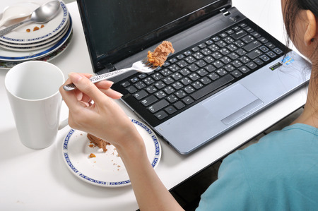 have lunch among stack of dirty plates while busy and using laptop, selective food focusの写真素材