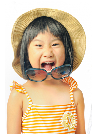 happy asian little girl in swimsuit ,sunglasses and sun hat on white backgroundの写真素材