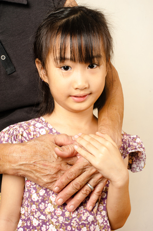 hand of senior hugging with her child. Asian llttle girl embrace the hands of an old woman with love.
の写真素材