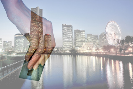 closeup woman's hand hold credit card with space for items over night city background.Business and holiday concept.の写真素材