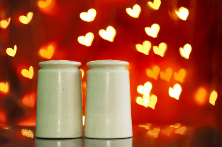 Salt and pepper shakers with heart bokeh background.Concept of love, Valentine, soulmate, destiny.の写真素材
