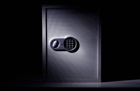 Strongbox steel safe with digital combination code lock on a dark background with falling lightの写真素材