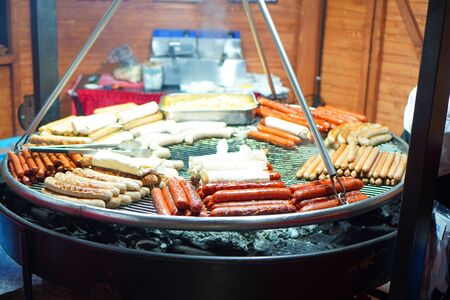 Grilled sausages. Street food. Many sausages grilled on a big bbq grill. の写真素材