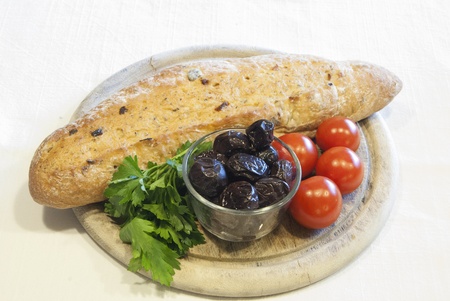 Homemade organic baguette bread with olives, cherry tomatoes and parsleyの写真素材