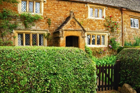 Old country stone house hedgerow wooden doorのeditorial素材