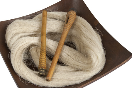 Raw silk yarn and spools of old loom in wooden platterの写真素材