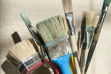 Bunch of various used paintbrushes on canvas backgroundの写真素材