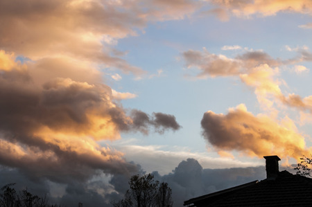 House roof silhouette on cloudy sunset backgroundの写真素材