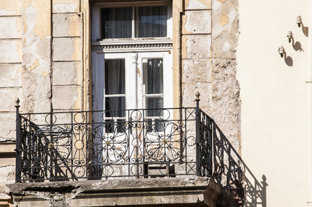 Grunge weathered old crumbling balcony with wooden door of neglected townhouseの写真素材
