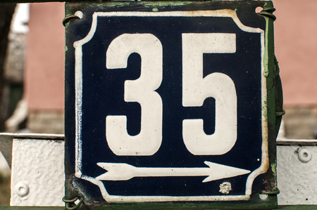 Weathered grunge square metal enameled plate of number of street address with number 35 closeupの写真素材