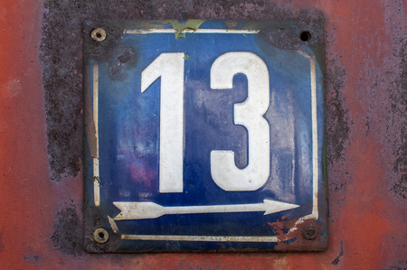 Weathered grunge square metal enameled plate of number of street address with number 13 closeupの写真素材