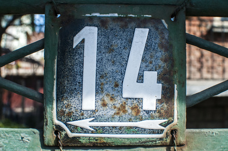 Weathered grunge square metal enameled plate of number of street address with number 14 closeupの写真素材