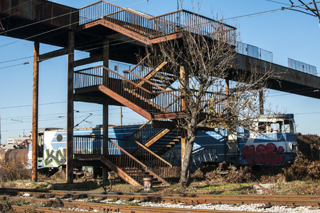 Abandoned vintage grunge train under rusty iron pedestrian bridge