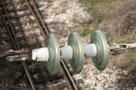 High-voltage ceramic insulator on railway tracks backgroundの写真素材