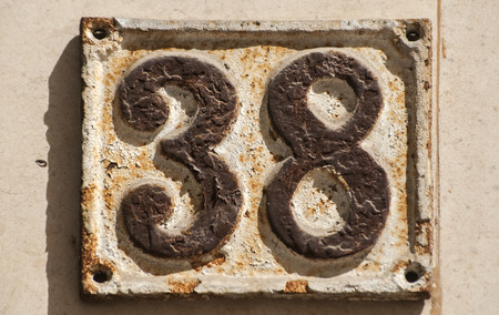 Old retro weathered cast iron plate with number 38