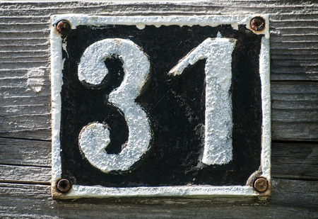 Old retro weathered cast iron plate with number 31