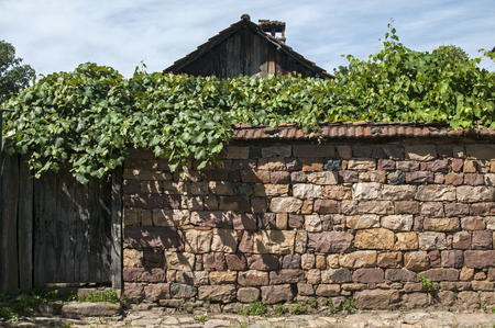 Stone dry masonry wall fence and wooden door of country houseの写真素材