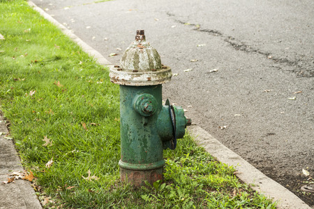 Classic weathered fire hydrant by pedestrian roadの写真素材