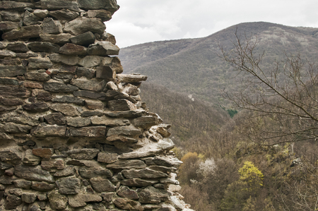 Ruins of medieval stone fortress on mountain landscape background in springtimeの写真素材