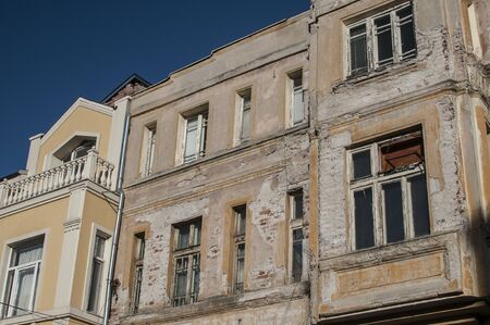 Old retro building weathered neglected facade closeup in sunny dayの写真素材