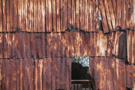 Old weathered corroded rusty tin wall surface panels closeup as grunge backgroundの写真素材