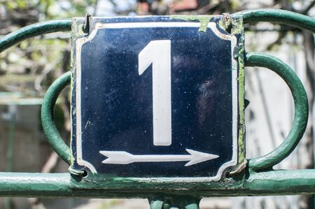 Weathered grunge square metal enameled plate of number of street address with number 1 closeupの写真素材
