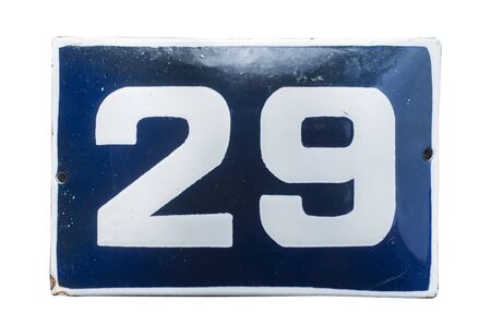 Weathered grunge square metal enameled plate of number of street address with number 29 closeup isolated on white backgroundの写真素材