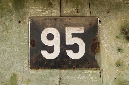 Weathered grunge square metal enameled plate of number of street address with number 95 closeupの写真素材