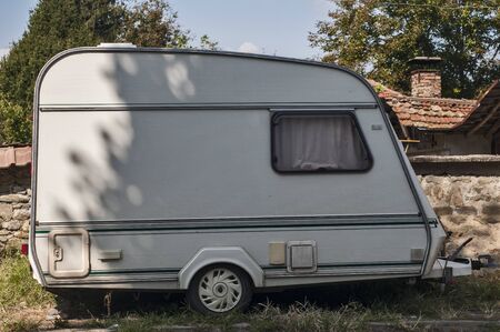 Old vintage caravan side view closeup at country house in sunny dayの写真素材
