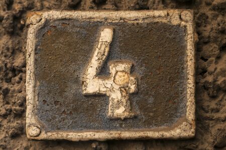 Old retro weathered cast iron plate with number 4 closeupの写真素材