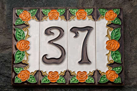 Weathered grunge square faience enameled decorated plate of number of street address with number 37...