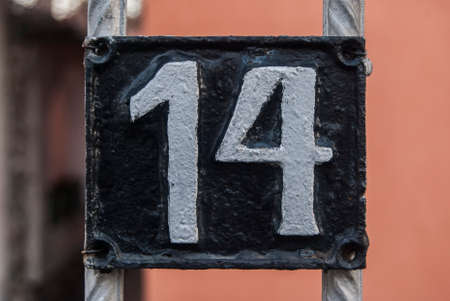 Old retro weathered cast iron plate with number 14 closeup