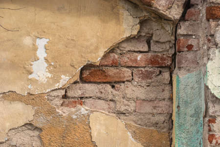 Old damaged plastered facade house wall closeup as grunge background