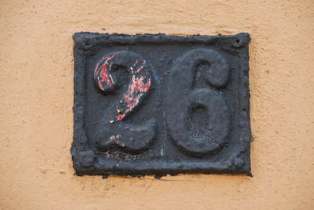 Old retro weathered cast iron plate with number 26 closeup