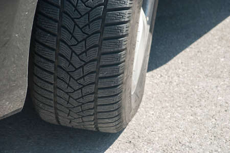 Car tyre on asphalt road surface closeup