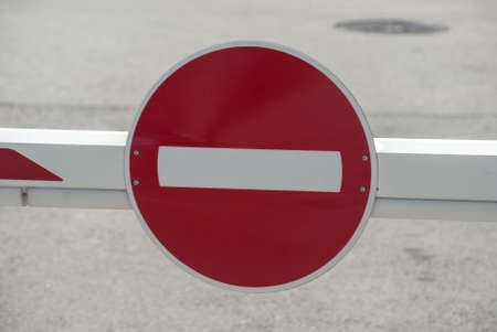 Red road traffic stop sign closeup on car parking barrier