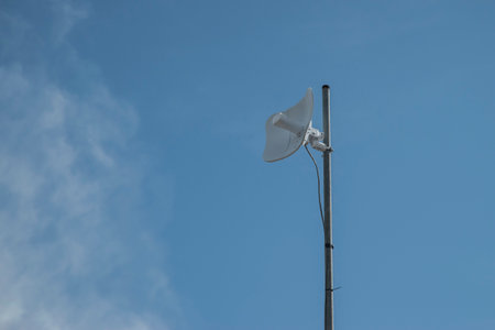 Receiver for mobile internet on pole on blue sky background